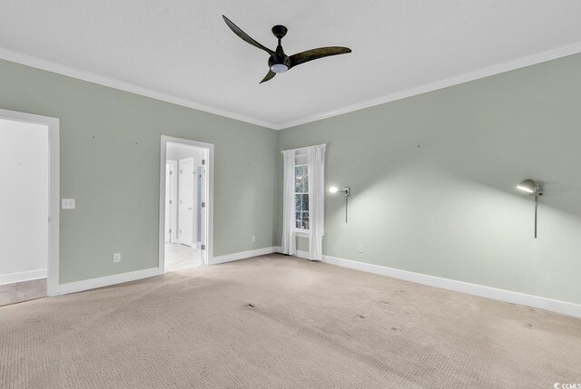 spare room featuring crown molding, light carpet, and ceiling fan