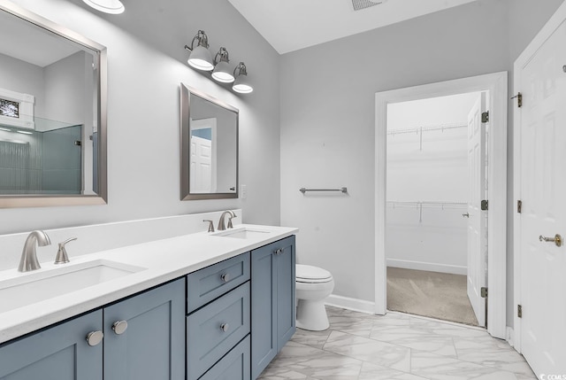 full bath with a walk in closet, marble finish floor, a sink, and double vanity