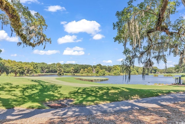 view of home's community featuring a lawn, a water view, and golf course view