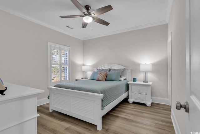 bedroom featuring ceiling fan, ornamental molding, and wood-type flooring