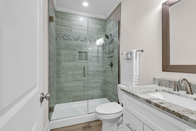 bathroom featuring hardwood / wood-style flooring, vanity, a shower with shower door, and toilet