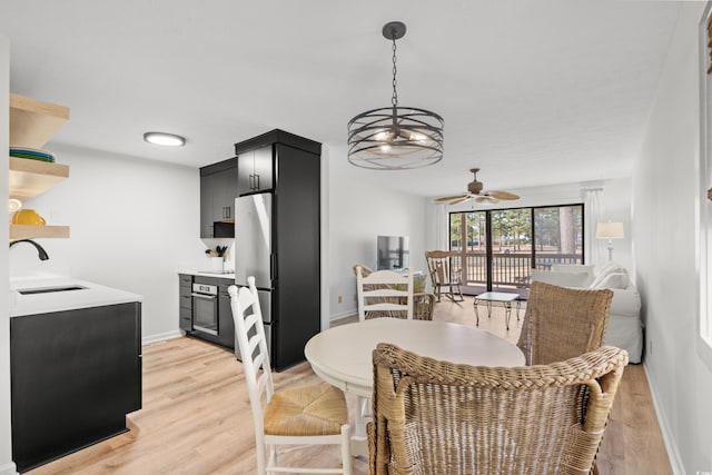 dining space with sink, light hardwood / wood-style floors, and ceiling fan