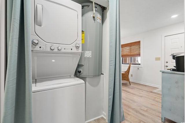 washroom with stacked washer / dryer and light hardwood / wood-style flooring