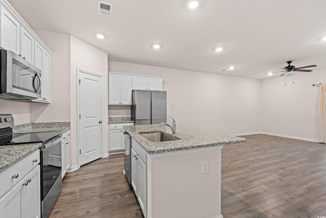 kitchen featuring sink, stainless steel appliances, light stone counters, an island with sink, and white cabinets