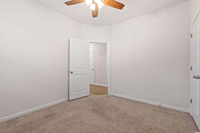 empty room with ceiling fan and light colored carpet