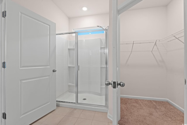 bathroom featuring a shower with door and tile patterned flooring