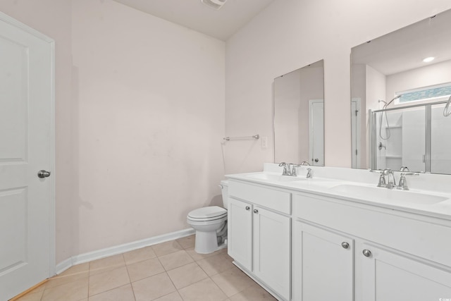 bathroom featuring tile patterned flooring, vanity, a shower with shower door, and toilet