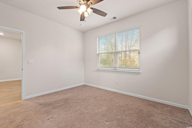 carpeted spare room with ceiling fan