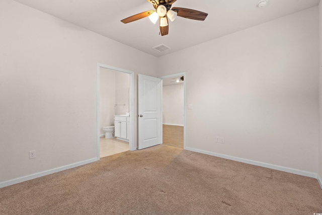 unfurnished bedroom featuring connected bathroom, light colored carpet, and ceiling fan