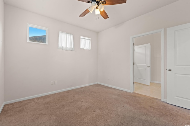 spare room featuring a wealth of natural light, light carpet, and ceiling fan