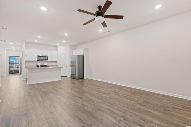 unfurnished living room with ceiling fan and light hardwood / wood-style floors