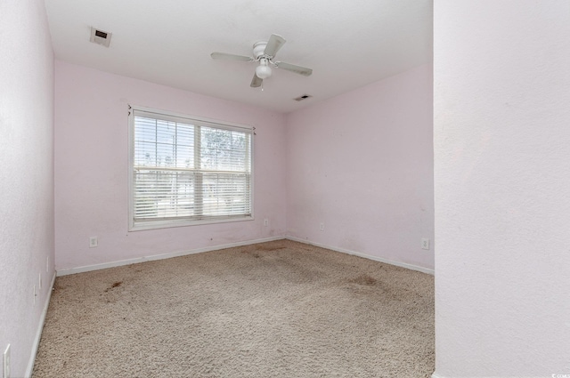 spare room featuring ceiling fan and light carpet