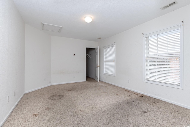 carpeted empty room with a textured ceiling