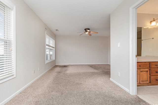 carpeted spare room with ceiling fan