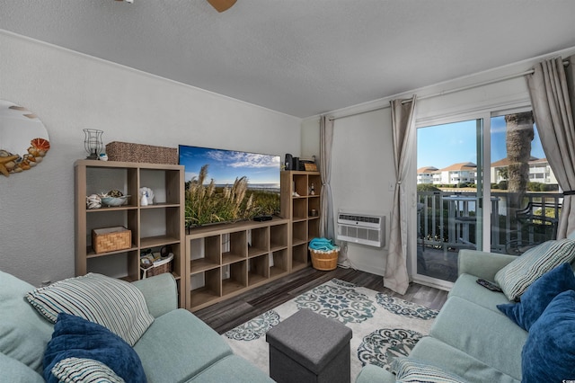 living room featuring a textured ceiling, wood-type flooring, and a wall mounted AC