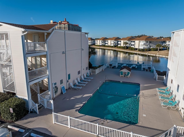 view of swimming pool with a patio and a water view