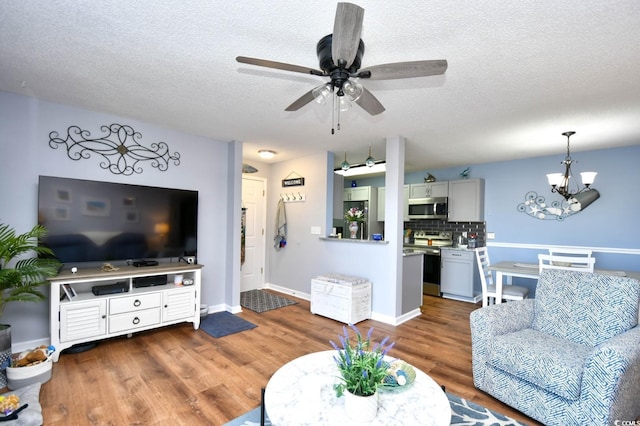 2225 Essex Dr Unit F, Surfside Beach, SC 29575 - living room featuring baseboards, wood finished floors, a textured ceiling, and ceiling fan with notable chandelier