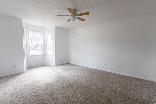 carpeted empty room with ceiling fan and a textured ceiling