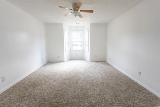 empty room featuring ceiling fan, a textured ceiling, and carpet