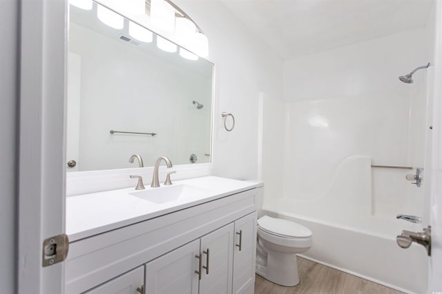 full bathroom with hardwood / wood-style flooring, shower / bathtub combination, vanity, and toilet