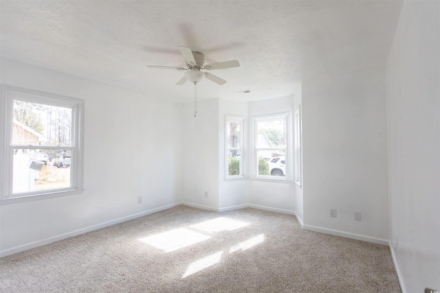 unfurnished room featuring light carpet, ceiling fan, and a textured ceiling