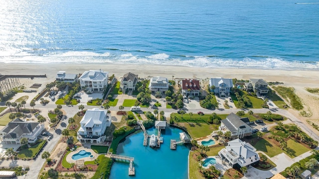 drone / aerial view featuring a water view, a residential view, and a view of the beach