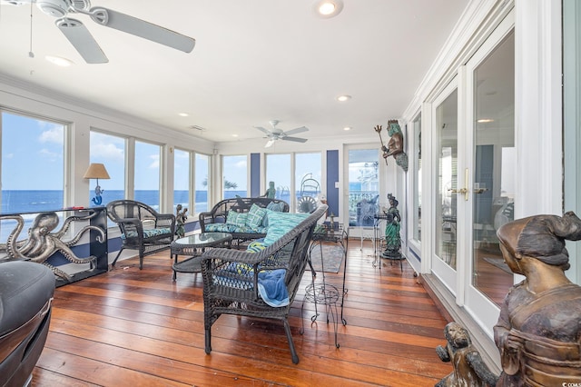 sunroom / solarium with a water view, visible vents, a ceiling fan, and french doors