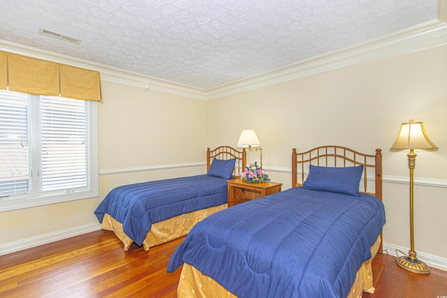 bedroom featuring wood-type flooring, a textured ceiling, and crown molding