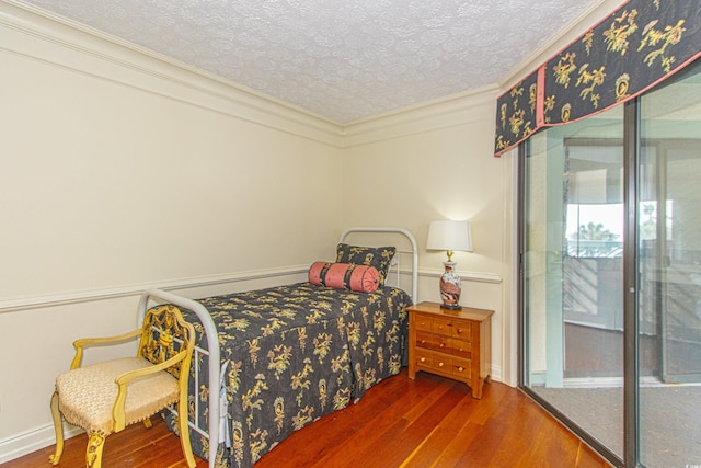 bedroom featuring hardwood / wood-style floors, crown molding, and a textured ceiling