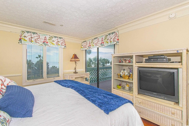 bedroom with ornamental molding, access to exterior, and a textured ceiling