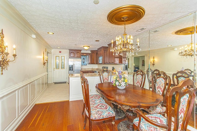 dining room featuring dark hardwood / wood-style flooring, a chandelier, and a textured ceiling