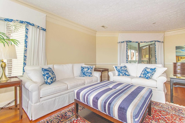 living room with crown molding, hardwood / wood-style flooring, and a textured ceiling