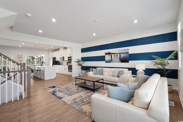 living room with hardwood / wood-style flooring and sink