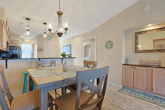 dining area featuring light wood-type flooring and a notable chandelier