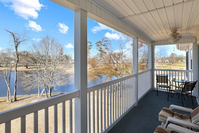 balcony with ceiling fan and a water view