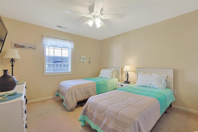 carpeted bedroom featuring a textured ceiling and ceiling fan