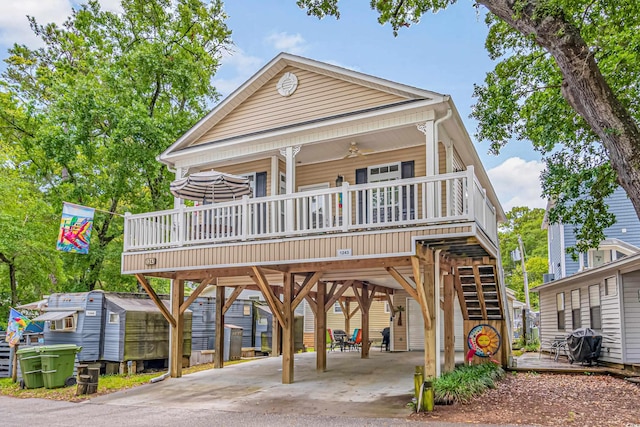 raised beach house with a carport, a porch, and ceiling fan