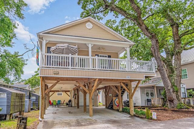 view of front facade with ceiling fan, a carport, and a porch