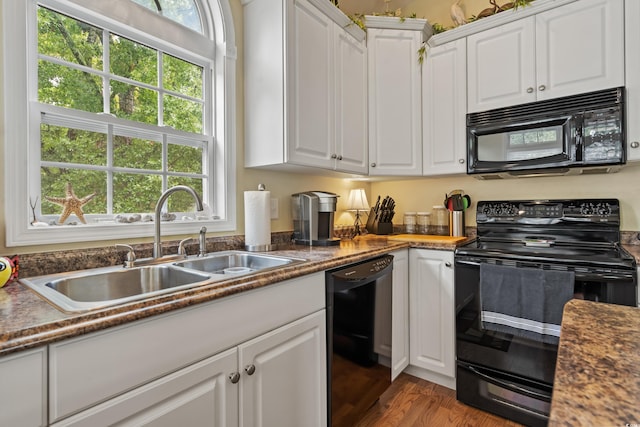 kitchen with white cabinetry, plenty of natural light, sink, and black appliances