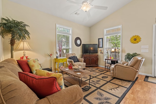 living room with lofted ceiling, plenty of natural light, ceiling fan, and light wood-type flooring