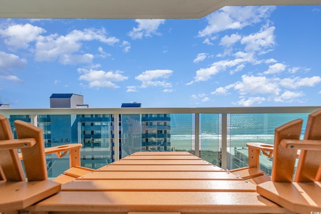 balcony featuring a view of the beach and a water view