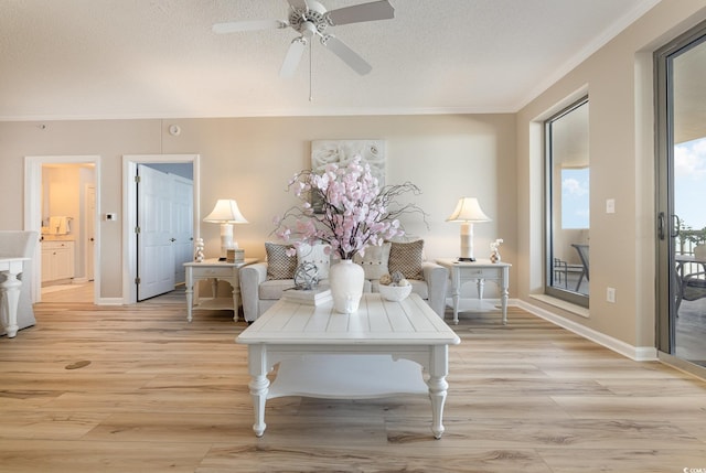 living room with ornamental molding, ceiling fan, a textured ceiling, and light hardwood / wood-style floors