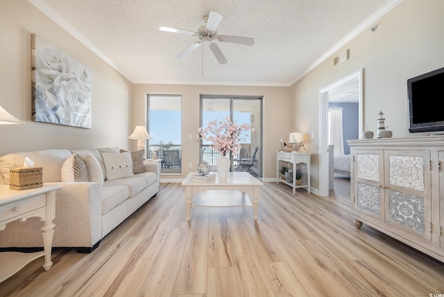 living room featuring crown molding, ceiling fan, light hardwood / wood-style floors, and a textured ceiling