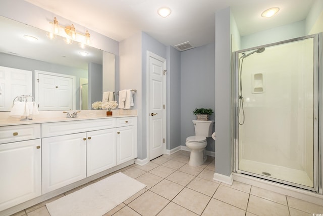 bathroom featuring tile patterned floors, toilet, a shower with door, and vanity