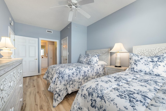 bedroom featuring light hardwood / wood-style flooring, ceiling fan, vaulted ceiling, and a textured ceiling