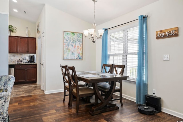 dining room featuring an inviting chandelier, dark hardwood / wood-style floors, and vaulted ceiling