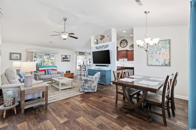 dining area featuring ceiling fan with notable chandelier, dark hardwood / wood-style floors, and vaulted ceiling