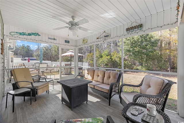 sunroom with ceiling fan and wooden ceiling