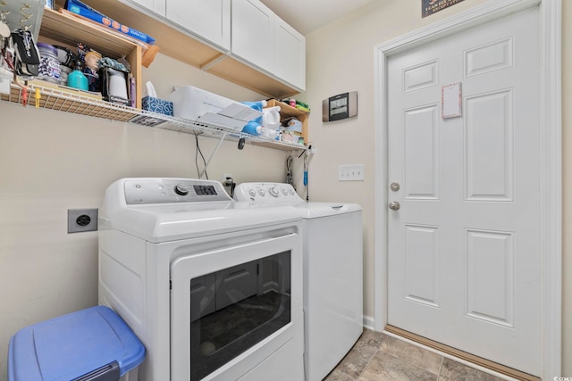 clothes washing area with cabinets and washer and clothes dryer