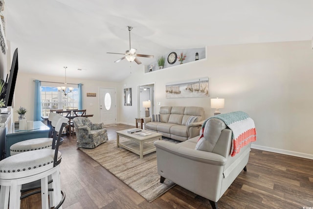 living room featuring ceiling fan with notable chandelier, dark wood-type flooring, and vaulted ceiling